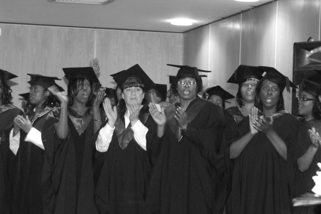 BIBS graduates in caps and gowns worshipping together at a graduation ceremony